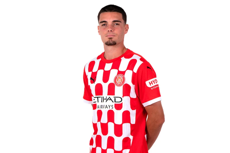 Retrato de Miguel Gutiérrez con la equipación oficial del Girona FC, posando de pie sobre fondo blanco y mirando a cámara.