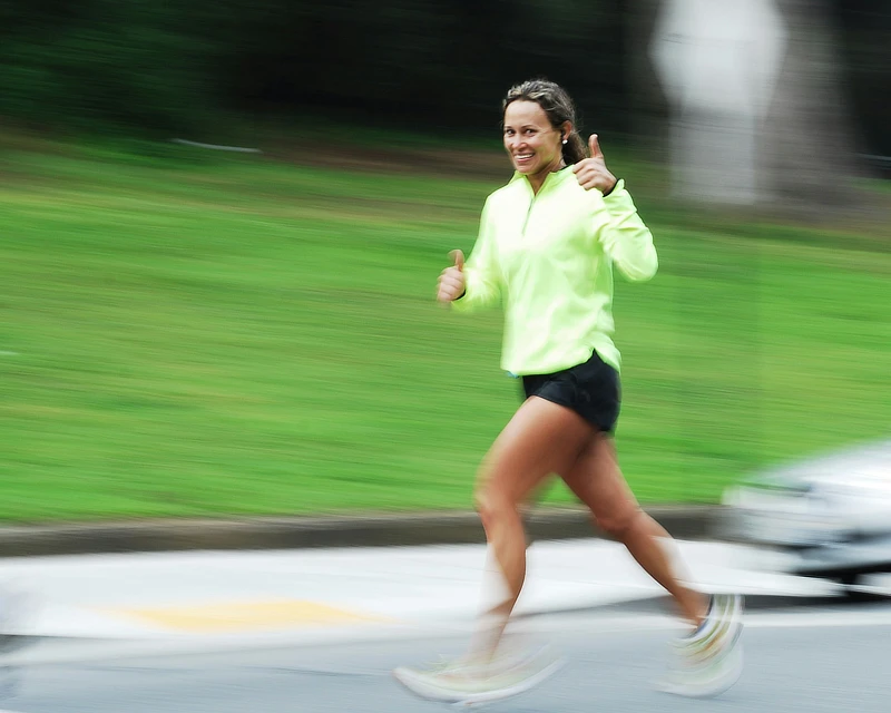 Deportista sonriente corriendo al aire libre tras completar recuperación de rodilla, ejemplo de retorno progresivo al deporte.