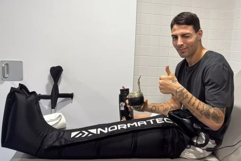 El futbolista argentino Ivo Mammini durante una sesión de recuperación de rodilla en Barcelona, con una bota de masaje dinámico de compresión de aire en la pierna y gesto positivo tras su cirugía.