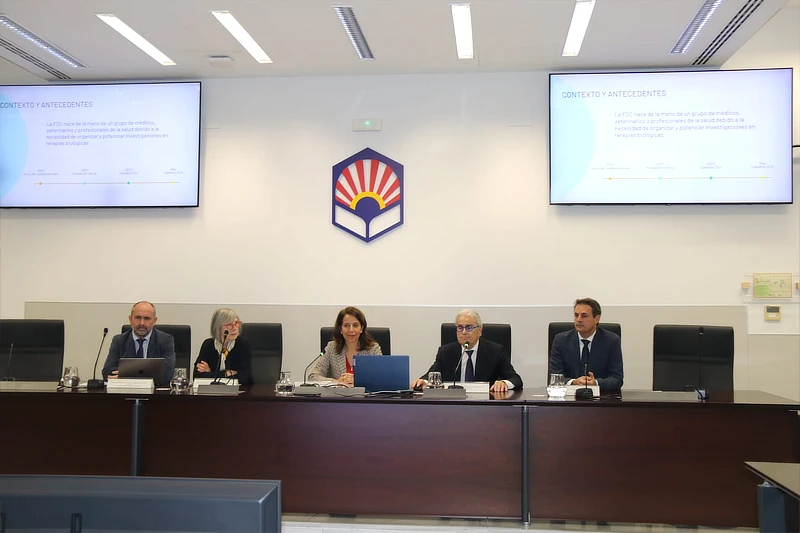 Mesa presidencial durante el acto académico de inauguración de la Cátedra Fundación García Cugat en la Universidad de Córdoba, con ponentes sentados y pantallas informativas al fondo.