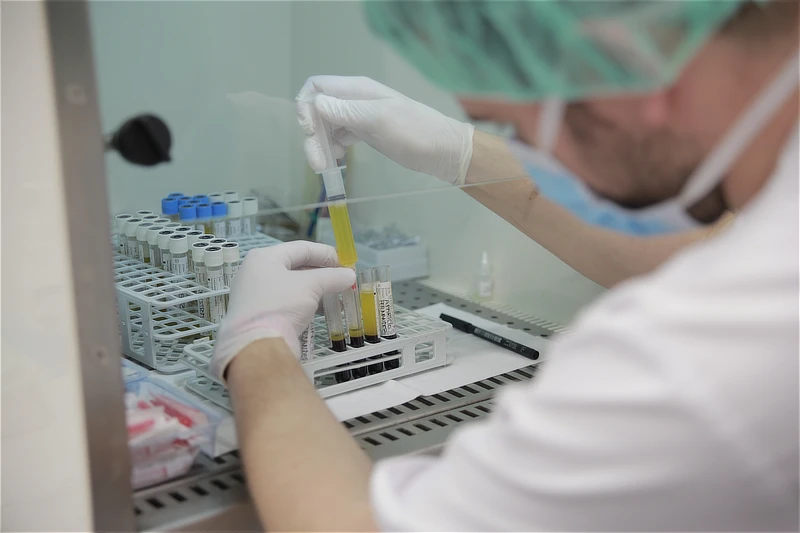 Técnico de laboratorio manipulando tubos con plasma rico en plaquetas dentro de una cabina de bioseguridad durante el proceso de preparación del PRP.