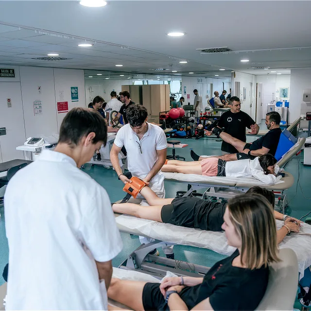Professionals assisting several patients in the rehabilitation and physiotherapy room at Instituto Cugat in Barcelona, equipped for personalized functional recovery.