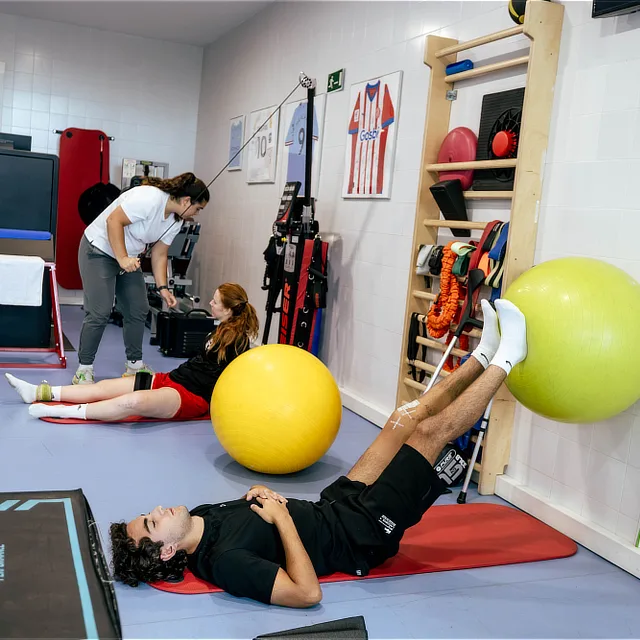 Patients performing supervised therapeutic exercise in a rehabilitation and physiotherapy gym to improve strength, mobility, and stability.