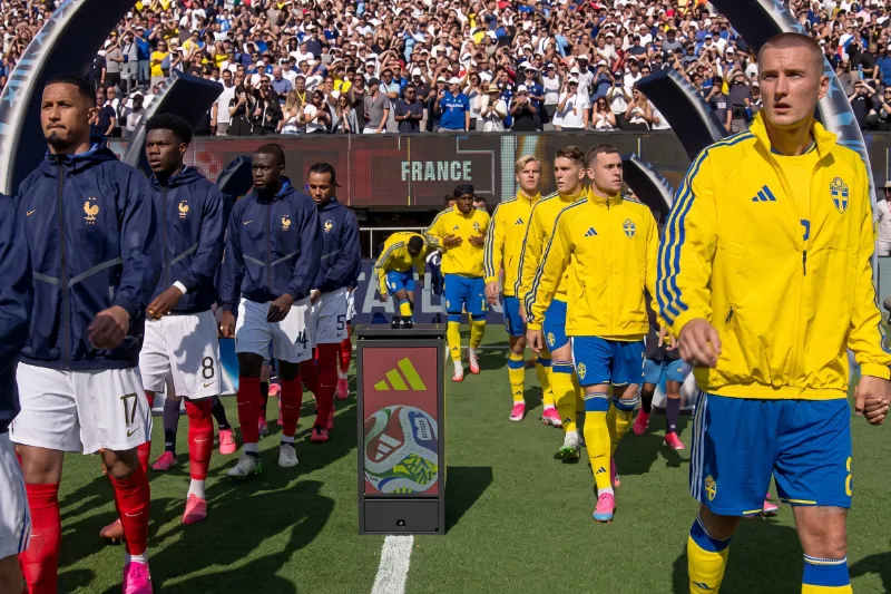 Jugadores de Francia y Suecia saltan al terreno de juego antes de un partido del Mundial 2026 con las gradas del estadio completamente llenas.