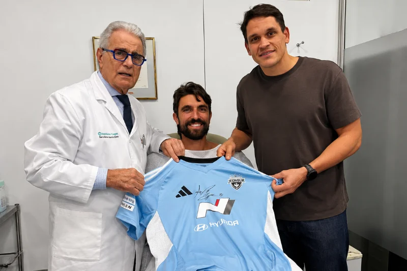 El Dr. Ramón Cugat junto a Andrea Compagno sosteniendo la camiseta del Jeonbuk Hyundai Motors.