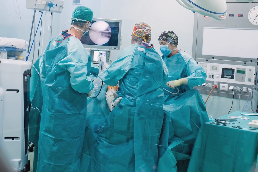 Equipo médico de Instituto Cugat Barcelona realizando una intervención por artroscopia con visualización de la articulación en el monitor