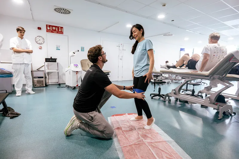 Paciente de Instituto Cugat en Barcelona realizando ejercicios de fortalecimiento de la musculatura glútea bajo la supervisión de un fisioterapeuta para tratar la trocanteritis.